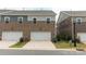 Brick townhome with two-car garage, neatly landscaped lawn, and green utility box at 5440 Kinsbridge Dr, Charlotte, NC 28227