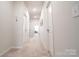 Bright hallway with soft carpet, recessed lighting, and multiple doorways at 5440 Kinsbridge Dr, Charlotte, NC 28227