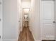 Hallway featuring wood floors and an open view of the powder room at 5440 Kinsbridge Dr, Charlotte, NC 28227