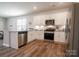 Stylish kitchen boasts stainless steel appliances, white cabinets, and wood flooring at 5440 Kinsbridge Dr, Charlotte, NC 28227