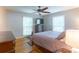 This bedroom features a bed, a dresser, a ceiling fan, and hardwood floors at 6128 Coatbridge Ln, Charlotte, NC 28212