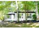 Beautiful exterior of a white house featuring green surroundings, complemented by lush landscaping and inviting curb appeal at 6128 Coatbridge Ln, Charlotte, NC 28212