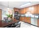 A cozy kitchen featuring wood cabinets, a dining table and chairs, and stainless steel appliances at 6128 Coatbridge Ln, Charlotte, NC 28212