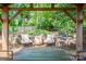 Charming outdoor patio featuring ample seating under a wooden pergola and stone flooring at 6128 Coatbridge Ln, Charlotte, NC 28212