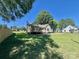 The backyard has a lush green lawn with mature trees and a wooden fence at 614 E Main Ave, Taylorsville, NC 28681