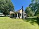 Exterior of a charming single-story home featuring a covered porch, chimney, and lush green lawn at 614 E Main Ave, Taylorsville, NC 28681