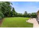 Expansive, green backyard featuring lush lawn, mature trees, and a patio area for outdoor living at 708 Ardent Trl, Belmont, NC 28012