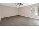 Well-lit, empty bedroom features sleek flooring, a ceiling fan, and a large picture window at 712 Mallard Head Ln, Mooresville, NC 28117