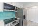 Modern kitchen featuring stainless steel appliances, turquoise backsplash, and white cabinets at 712 Mallard Head Ln, Mooresville, NC 28117