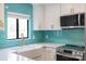 Modern kitchen view with a farmhouse sink, turquoise backsplash, and stainless steel appliances at 712 Mallard Head Ln, Mooresville, NC 28117