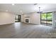Bright living room with modern gray flooring, fireplace, and sliding glass doors to a private balcony at 712 Mallard Head Ln, Mooresville, NC 28117