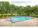 Community pool with surrounding trees, lounge chairs, and lush grass at 712 Mallard Head Ln, Mooresville, NC 28117