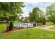 Community pool area with lounge chairs, mature trees, and green space at 712 Mallard Head Ln, Mooresville, NC 28117