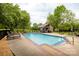Sparkling community pool with a covered lounge area, surrounded by lush greenery and comfortable lounge chairs at 712 Mallard Head Ln, Mooresville, NC 28117