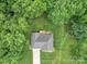 Aerial view of property showing mature trees, backyard deck, driveway, and lush lawn at 727 Cove Rd, Gastonia, NC 28052