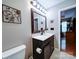 Bathroom features a dark wood vanity and a large mirror with decorative wall art at 727 Cove Rd, Gastonia, NC 28052