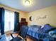Bedroom with hardwood floors, large window, a bed with blue spread and office chair at 727 Cove Rd, Gastonia, NC 28052