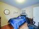 Comfortable bedroom features a blue-checkered bedspread, desk, and hardwood floors at 727 Cove Rd, Gastonia, NC 28052