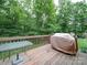 Wooden deck with table and covered grill overlooking a lush backyard at 727 Cove Rd, Gastonia, NC 28052