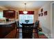 Sunlit dining area with dark wood table, adjacent to kitchen with granite countertops and warm cabinetry at 727 Cove Rd, Gastonia, NC 28052