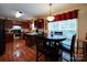 Bright dining area with wood floors, adjacent to kitchen with wooden cabinets and stainless appliances at 727 Cove Rd, Gastonia, NC 28052