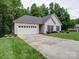 Single-Gathering home with attached garage, well-manicured lawn, and long driveway, framed by mature trees at 727 Cove Rd, Gastonia, NC 28052