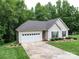 Inviting home with attached garage, well-kept lawn, and a long driveway, surrounded by lush trees at 727 Cove Rd, Gastonia, NC 28052