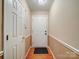 Hallway with hardwood floors leading to the front door, and a closet with classic white trim at 727 Cove Rd, Gastonia, NC 28052
