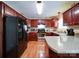 Well-lit kitchen featuring stainless appliances, granite counters, warm wood cabinets and hardwood floors at 727 Cove Rd, Gastonia, NC 28052