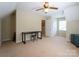 Bedroom with desk, ceiling fan, carpet floors, and natural light from a window at 7521 Surreywood Pl, Charlotte, NC 28270