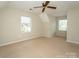 Bedroom with a ceiling fan, carpet floors, and natural light from two windows at 7521 Surreywood Pl, Charlotte, NC 28270