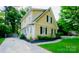 Side view of a charming two-story home with manicured lawn, black mulch landscaping and ample parking at 7521 Surreywood Pl, Charlotte, NC 28270