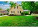 Charming two-story home with yellow siding, black shutters, and a well-manicured green lawn at 7521 Surreywood Pl, Charlotte, NC 28270