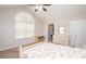 Bright bedroom featuring a vaulted ceiling, ceiling fan, carpeted floors, a large arched window and a walk-in closet at 8183 Sultana Cir, Charlotte, NC 28227