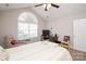 Bright bedroom featuring a ceiling fan, desk, and large window with ample natural light at 8183 Sultana Cir, Charlotte, NC 28227