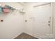 Laundry room featuring modern wood floors, neutral walls, and an exterior door at 8183 Sultana Cir, Charlotte, NC 28227