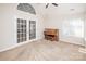 Bright living room with plush carpet, arched window, and French doors at 8183 Sultana Cir, Charlotte, NC 28227