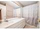 Bathroom featuring a double sink, a large mirror, cream walls, and a white shower curtain at 8219 Beardsley Dr, Charlotte, NC 28269