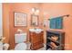 Bathroom with wood vanity, cream-colored walls, a toilet, and a framed picture at 8219 Beardsley Dr, Charlotte, NC 28269