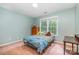 Bedroom with light green walls, a wooden dresser, neutral carpeting, and a large window at 8219 Beardsley Dr, Charlotte, NC 28269