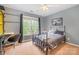 A bedroom with light gray walls, an iron bed frame, a ceiling fan, and wall shelving at 8219 Beardsley Dr, Charlotte, NC 28269