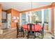 A dining room with black chairs, orange walls, a red tablecloth, and wood-style flooring at 8219 Beardsley Dr, Charlotte, NC 28269