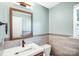 Cozy bathroom featuring a tiled accent wall, vessel sink, and wooden framed mirror at 867 Pecan Tree Ln, Fort Mill, SC 29715