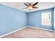 A peaceful bedroom featuring blue walls, neutral carpeting, and a ceiling fan at 867 Pecan Tree Ln, Fort Mill, SC 29715