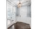 Bright foyer with hardwood floors, paneled walls, and an elegant light fixture above the door at 867 Pecan Tree Ln, Fort Mill, SC 29715