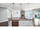 Kitchen island with granite countertops, stainless steel sink, and view to a stone fireplace and living room at 867 Pecan Tree Ln, Fort Mill, SC 29715