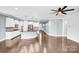 Open-concept living space with a kitchen island, living room, stone fireplace and hardwood floors at 867 Pecan Tree Ln, Fort Mill, SC 29715