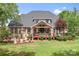 Rear exterior of a brick home with a covered deck and landscaped yard, perfect for outdoor enjoyment at 9112 Butterfly Ct, Gastonia, NC 28056