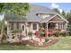 Rear exterior of a brick home with a covered deck, patio, and beautifully landscaped backyard at 9112 Butterfly Ct, Gastonia, NC 28056