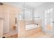 Bathroom featuring a glass-enclosed shower, soaking tub, and tile surround at 9112 Butterfly Ct, Gastonia, NC 28056